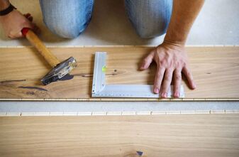 Handyman measuring a wooden floor
