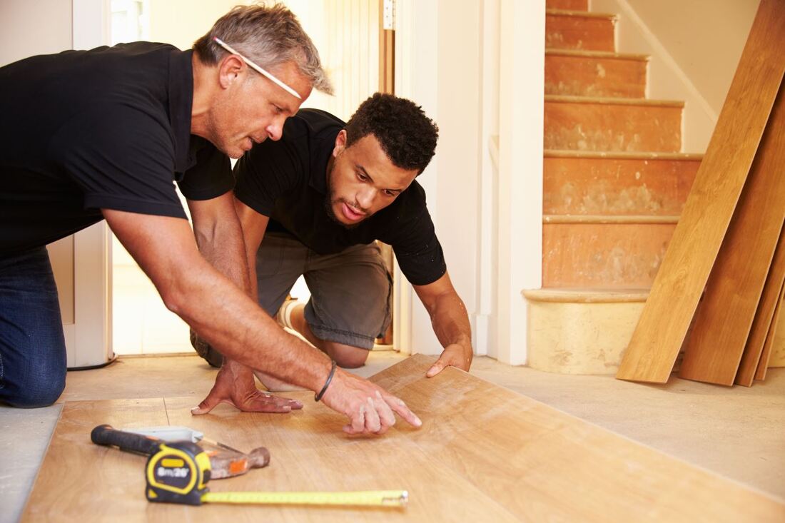 Low Angle View of two men installing some floorboards