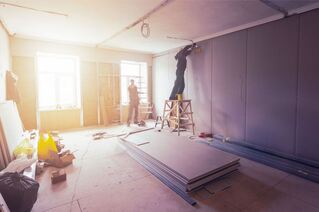 Men installing drywall in an apartment