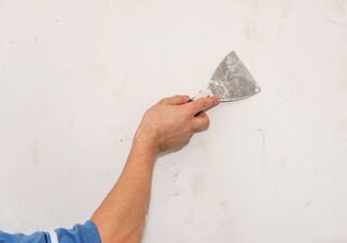 Handyman repairing a drywall hole