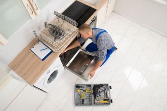 Overhead shot of a handyman fixing a dishwasher